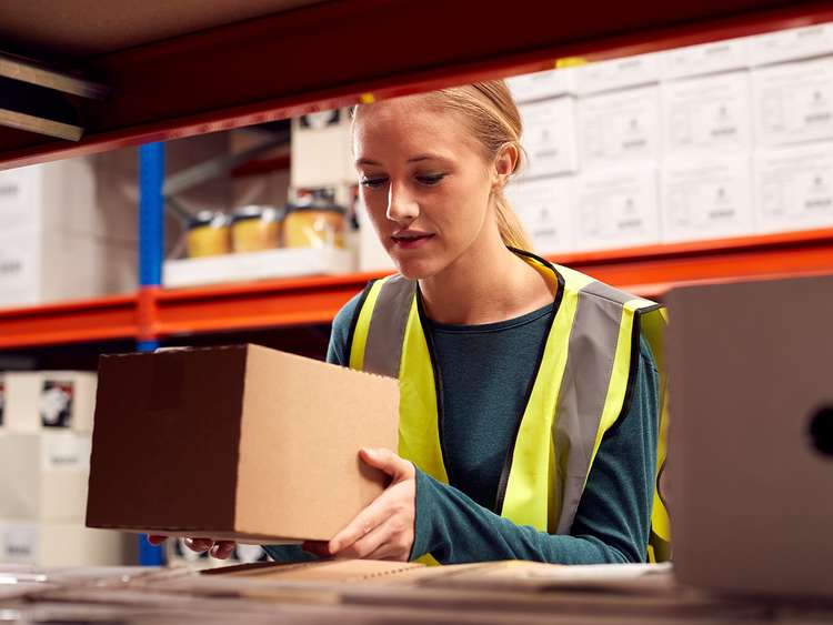 Operadora de picking realiza a recolha de produtos num armazém de eCommerce.