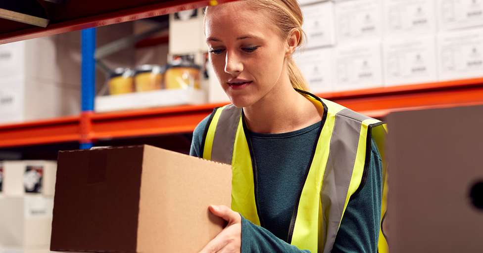 Operadora de picking realiza a recolha de produtos num armazém de eCommerce.